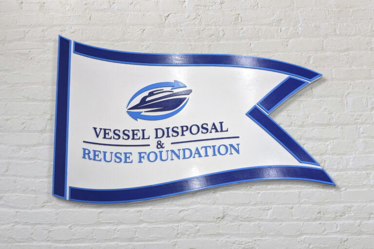 custom shape outlined personalized business sign made out of birch wood with a boat logo. Sign is the shape of a flag and has laser cut lettering featuring the company boat logo. Also has exterior clear coat finish applied