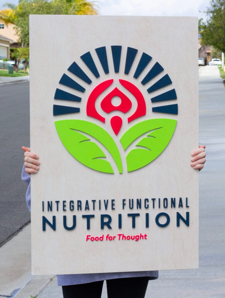 Custom business logo sign for a nutrition business. Laser-cut logo on a white-wash base shop sign