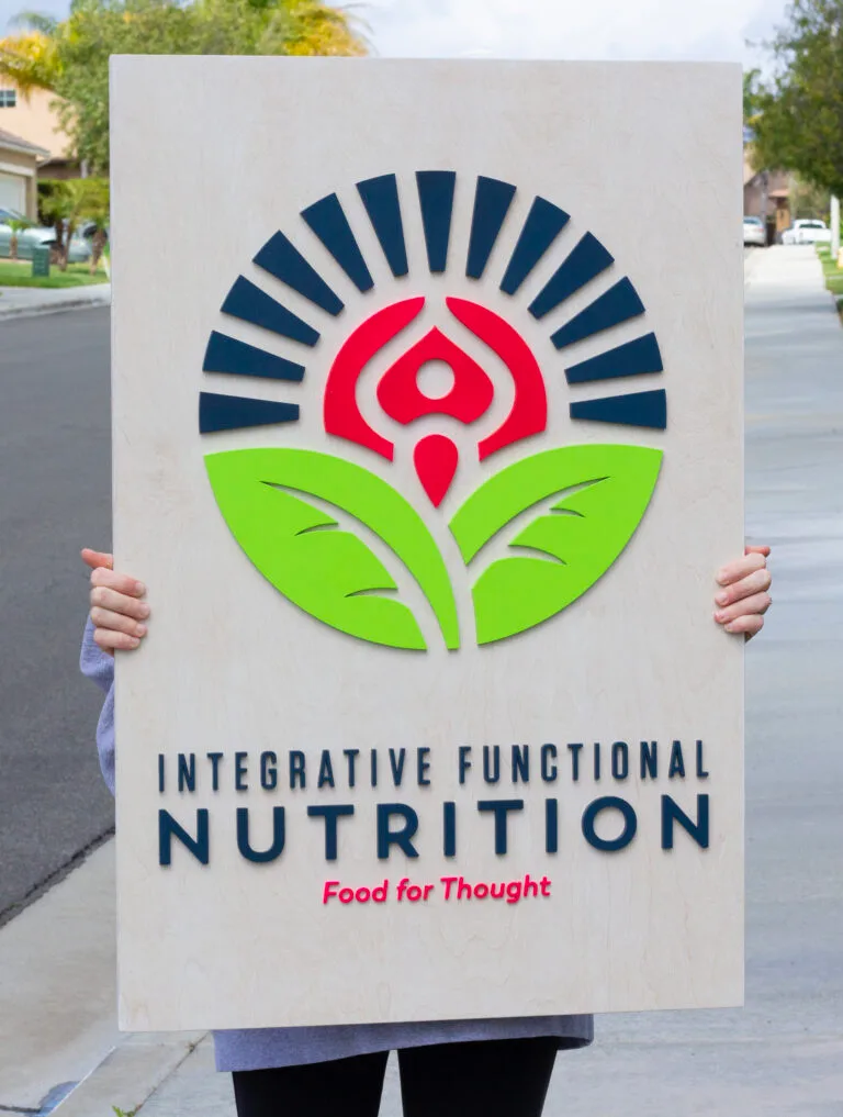 Custom business logo sign for a nutrition business. Laser-cut logo on a white-wash base shop sign