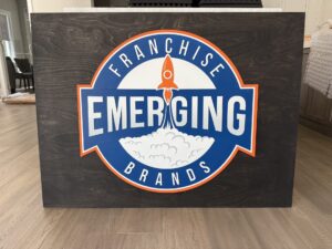 custom multi-layered sign with an ebony base and blue and orange logo