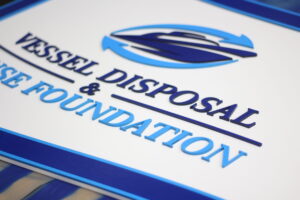 custom shape wood sign with a boat logo for a vessel disposal company