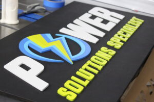 Custom business sign with multiple colors and 3D letters on an ebony base.