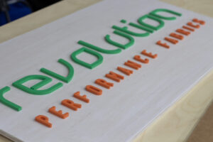 custom fabric company sign with laser cut logo on white wash base