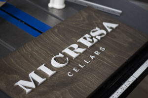 Wooden sign with dark walnut base and white 3D lettering for a winery, cellar, or vineyard. To be displayed in a storefront or shop