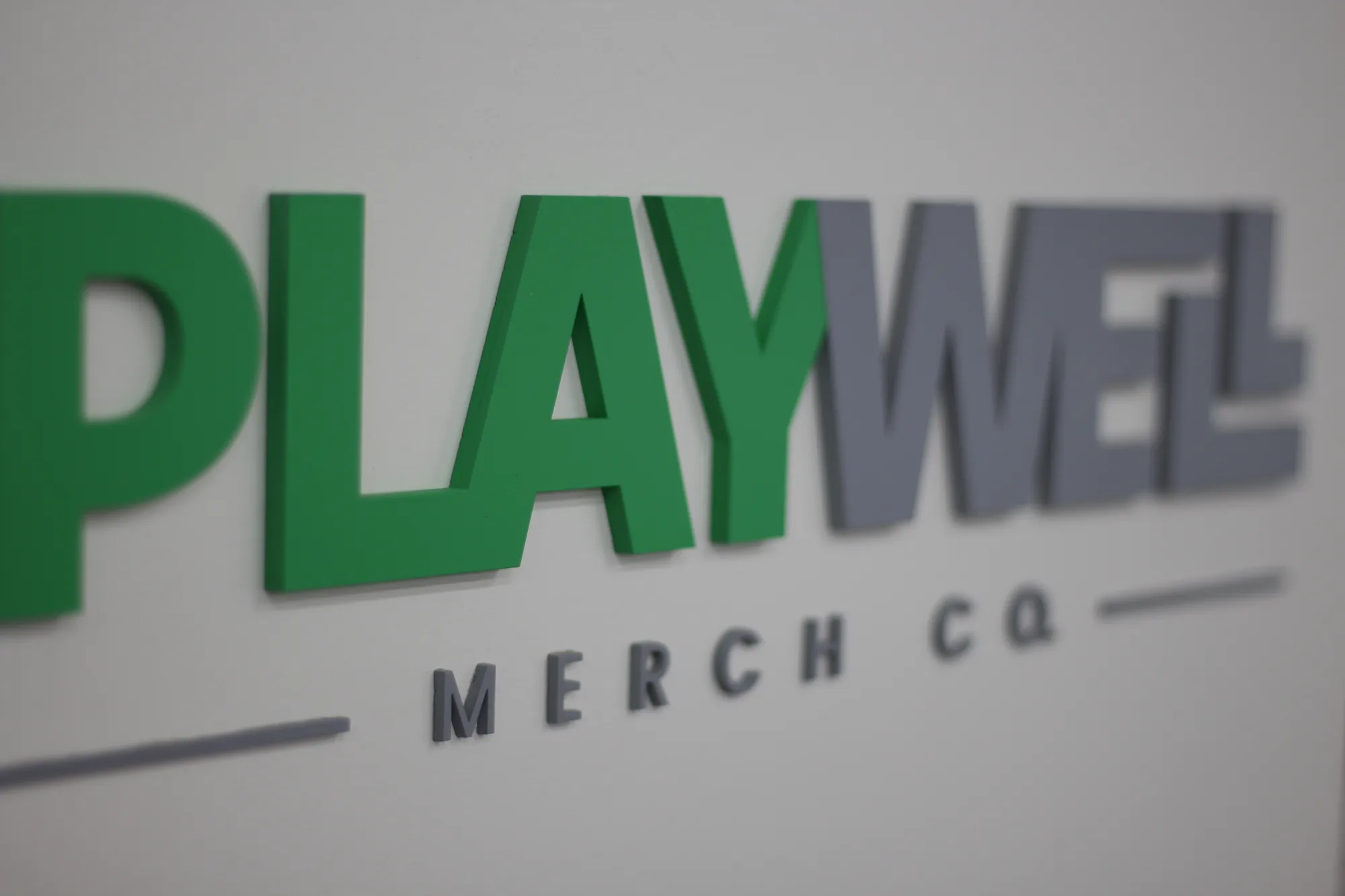 Custom painted white wood logo sign for an apparel brand
