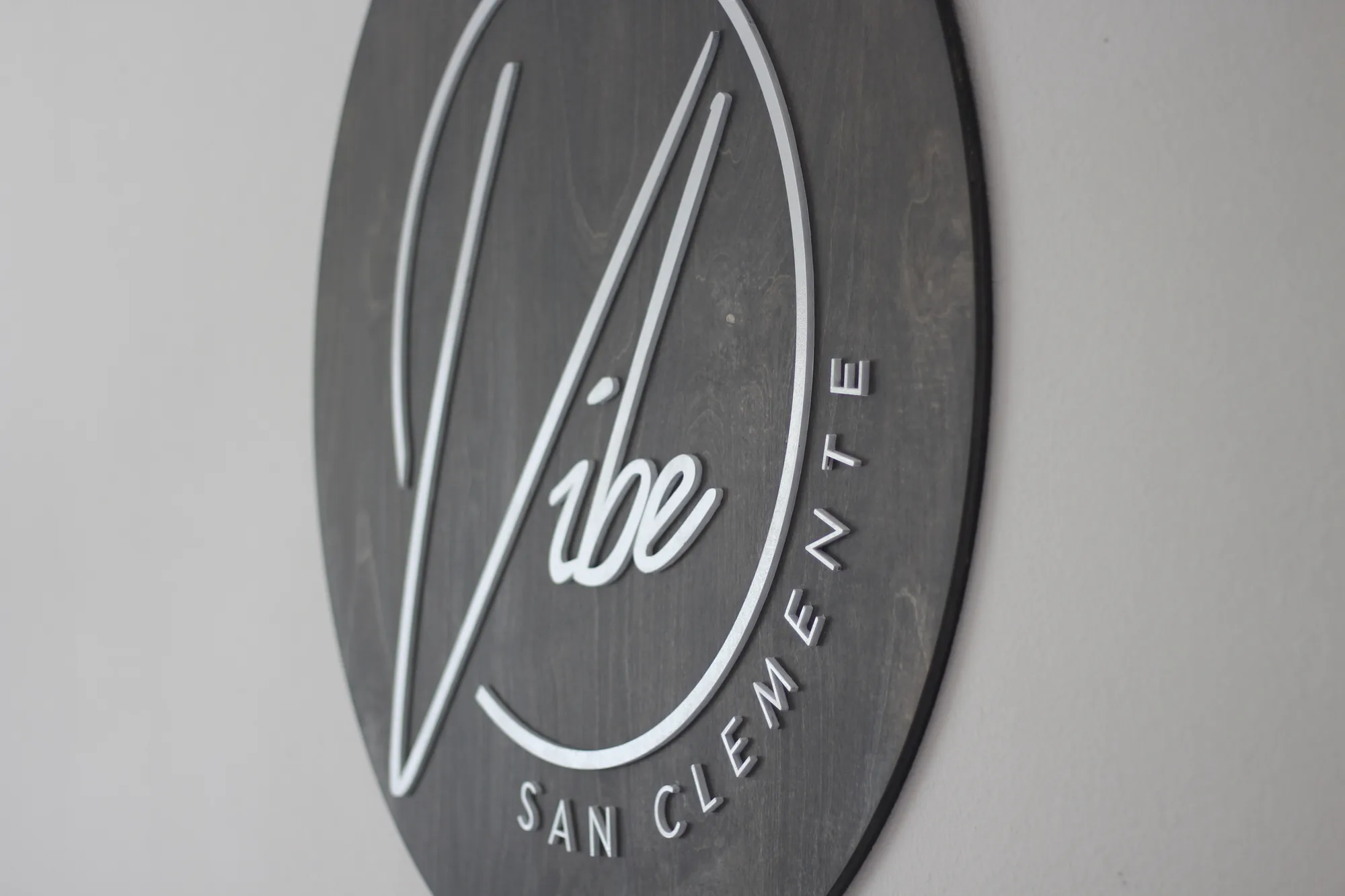 Weathered gray custom salon sign with a white logo