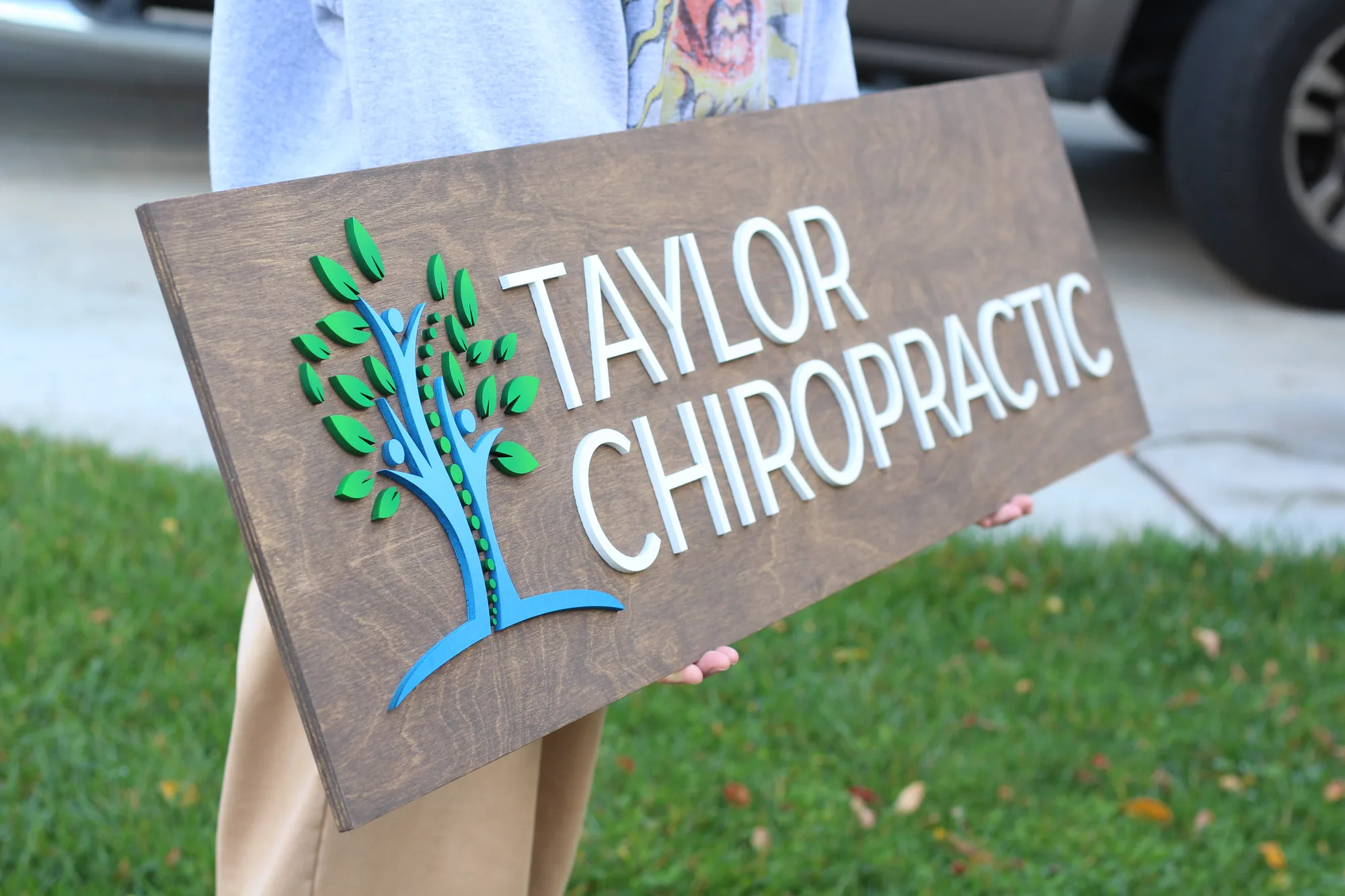 Chiropractic office wood logo sign mounted on the reception wall