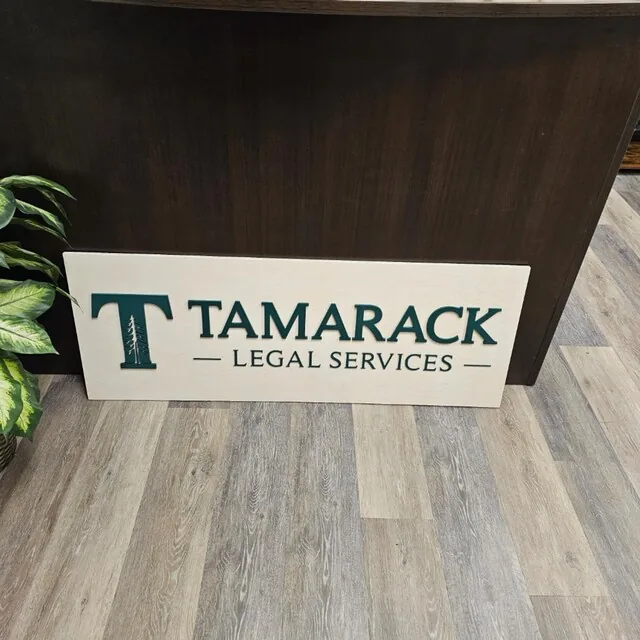 White wash custom wood law office reception sign with a green logo