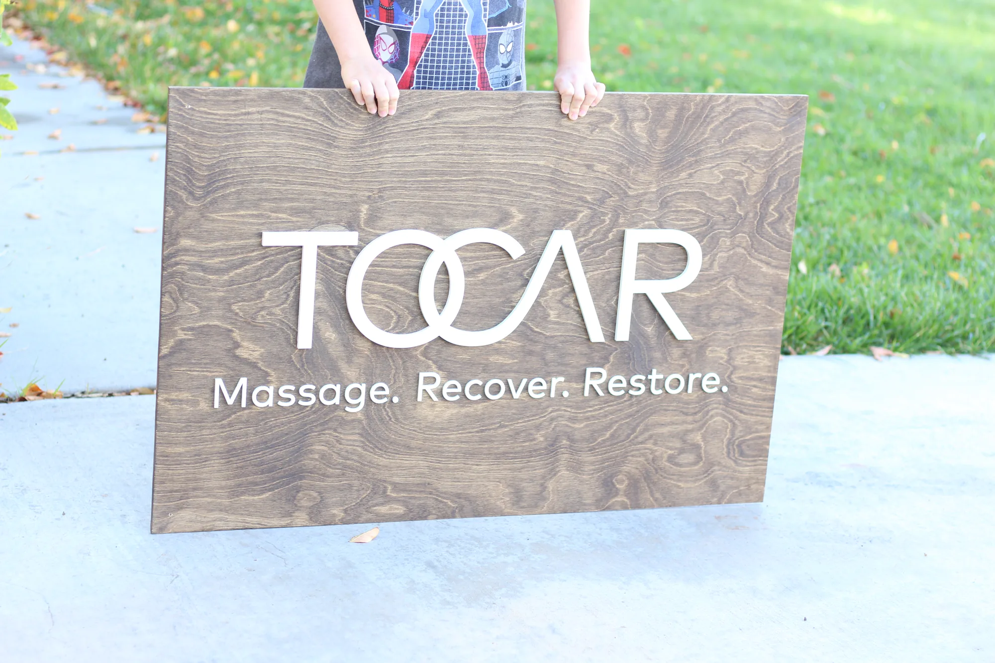 Aged walnut massage therapy sign with white and mint green lettering