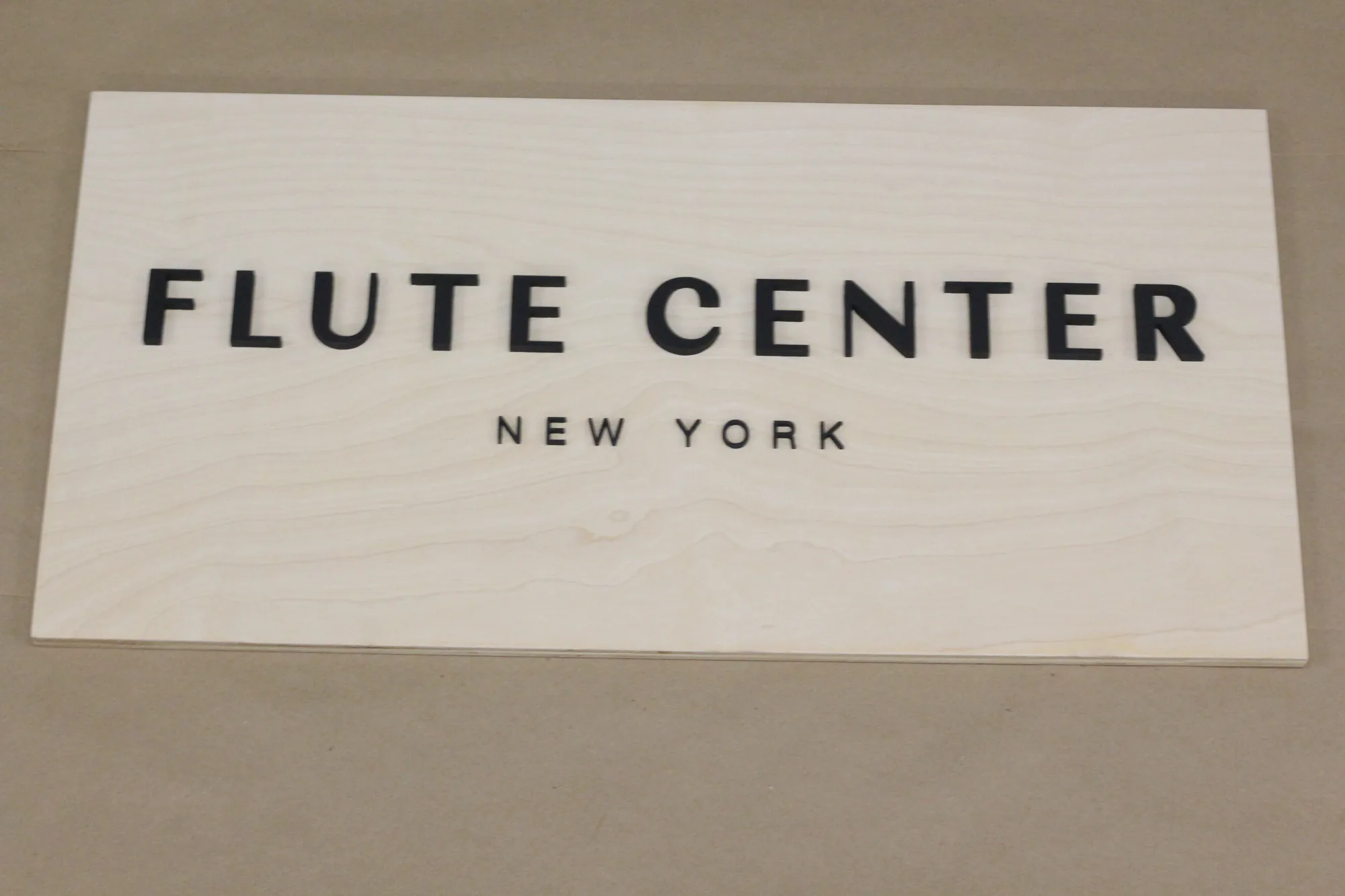 Natural birch music store sign with black lettering