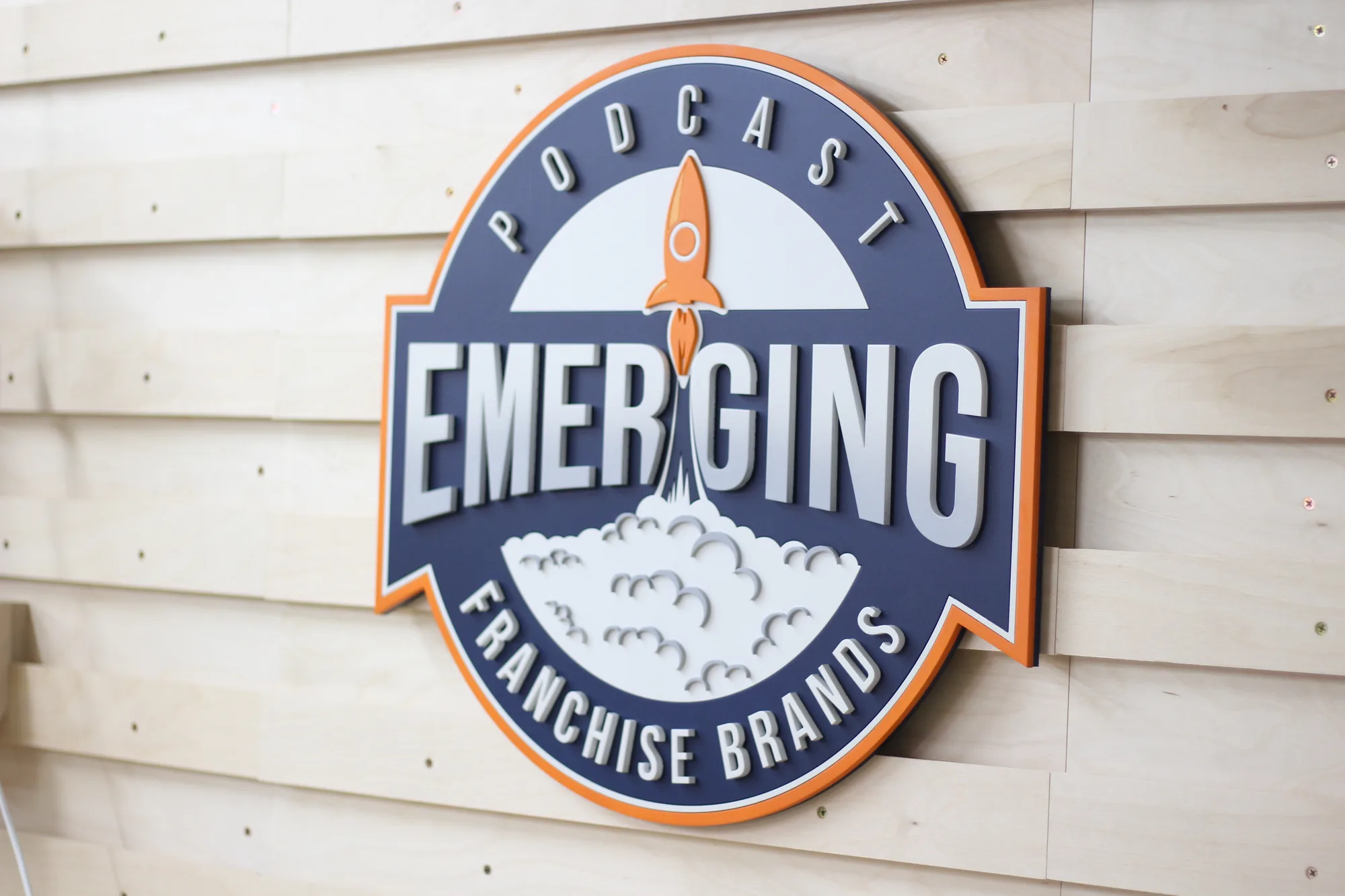 Ebony podcast studio sign with blue, white and orange logo