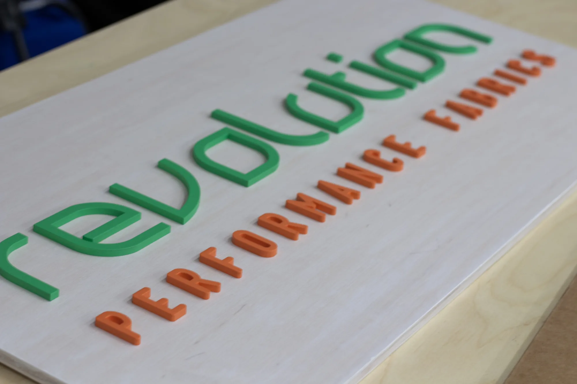 White wash textile company office sign with green and orange lettering