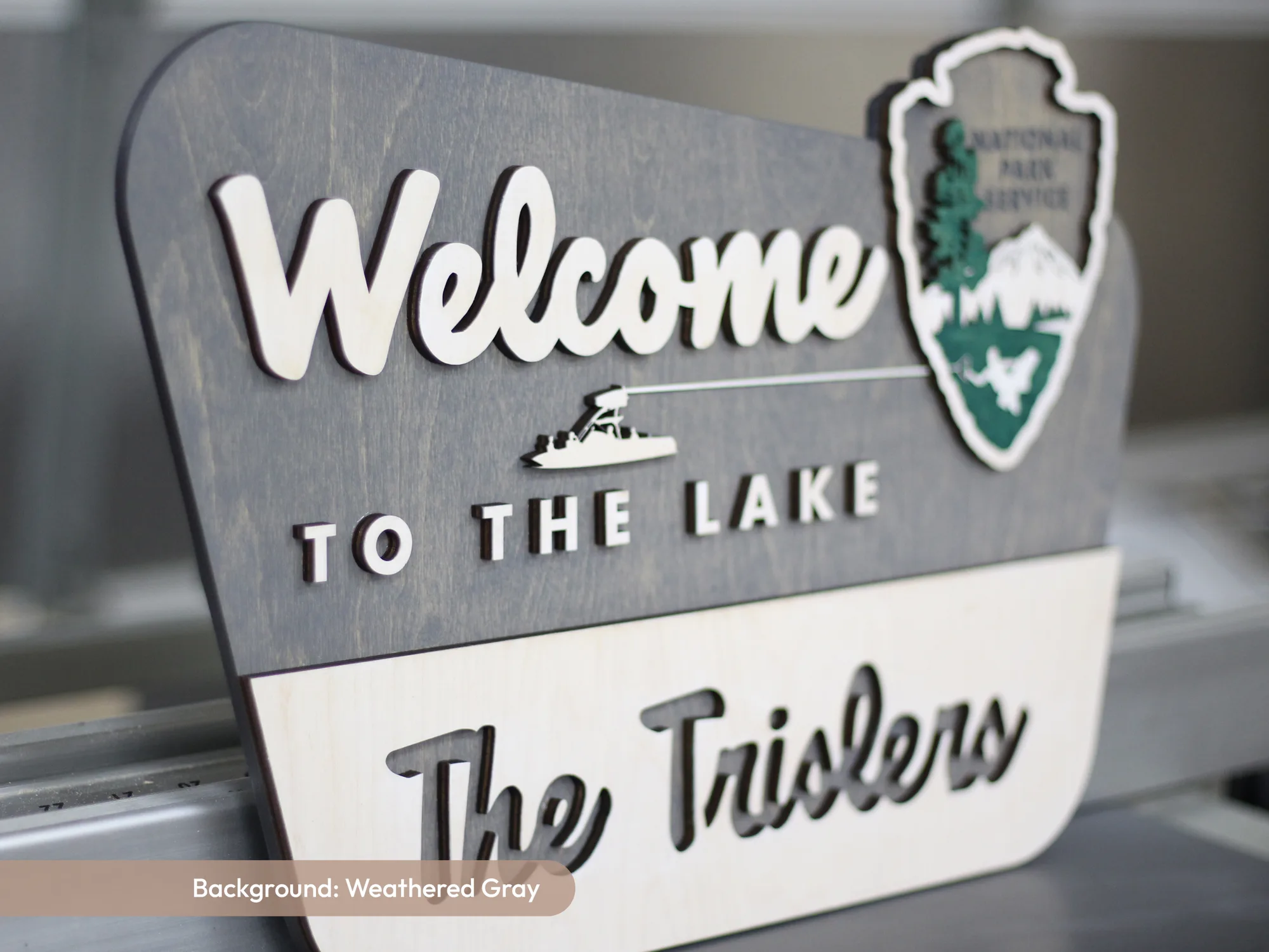 Weathered gray welcome to the lake park style sign with a family name